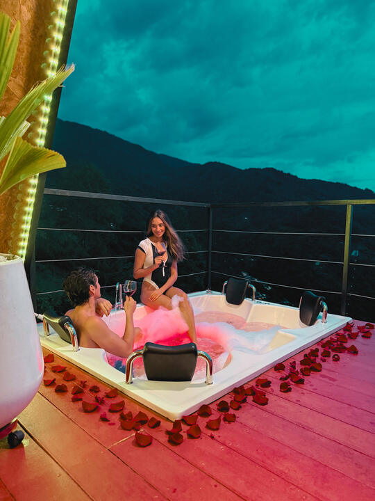 Jacuzzi con burbujas y pétalos frente a las montañas